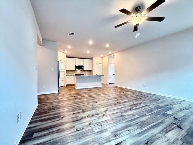 unfurnished living room with visible vents, baseboards, recessed lighting, dark wood-type flooring, and a ceiling fan