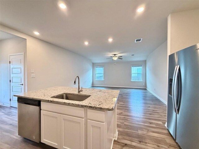 kitchen featuring appliances with stainless steel finishes, a sink, a ceiling fan, white cabinetry, and visible vents
