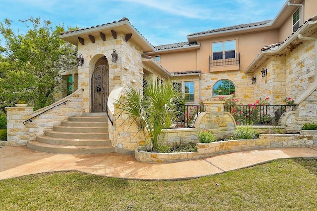 exterior space with a tiled roof, stone siding, and stucco siding