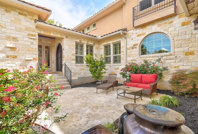 view of patio with outdoor lounge area and a balcony