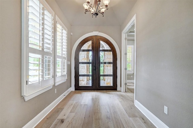 423 Bella Montagna Cir, Austin, TX 78734 - foyer featuring french doors, a chandelier, arched walkways, and plenty of natural light