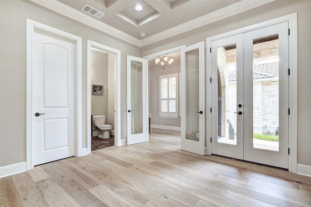 doorway to outside featuring a notable chandelier, french doors, light wood-type flooring, visible vents, and ornamental molding