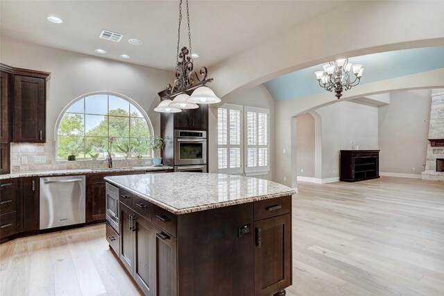 423 Bella Montagna Cir, Austin, TX 78734 - kitchen with stainless steel appliances, light wood finished floors, arched walkways, plenty of natural light, and recessed lighting