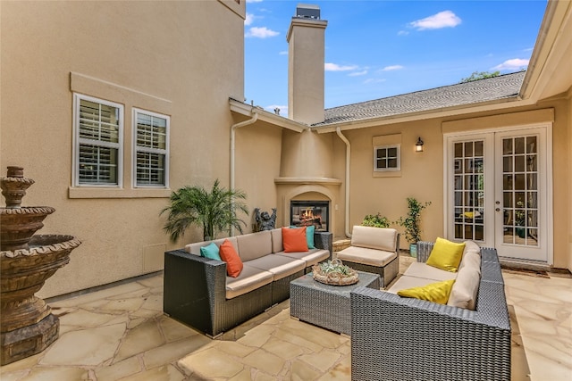 view of patio with an outdoor living space with a fireplace and french doors