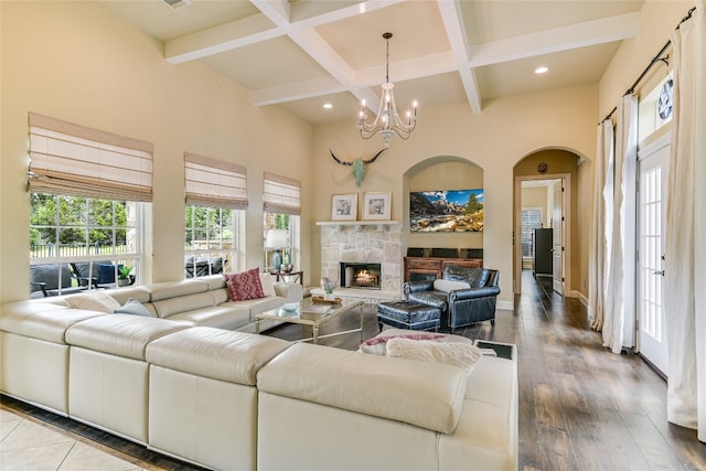 living room with an inviting chandelier, a fireplace, beamed ceiling, hardwood / wood-style flooring, and coffered ceiling