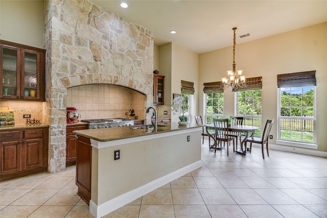 1916 Wimberly Ln, Austin, TX 78735 - kitchen featuring light tile patterned floors, backsplash, healthy amount of natural light, a chandelier, and a towering ceiling