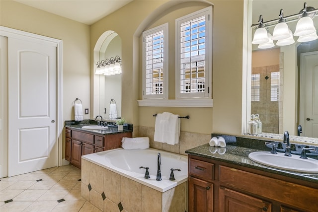 bathroom featuring a sink, tile patterned floors, plenty of natural light, and a bath
