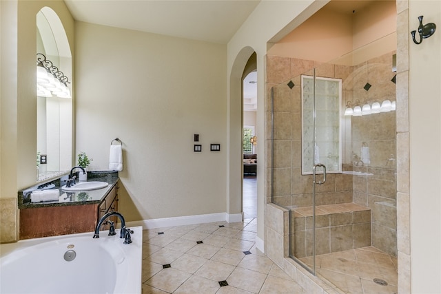 bathroom featuring tile patterned flooring, vanity, a bathing tub, and a shower stall