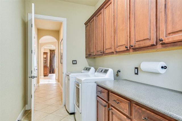 1916 Wimberly Ln, Austin, TX 78735 - washroom with arched walkways, washer and dryer, light tile patterned floors, cabinet space, and baseboards