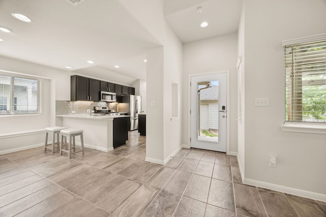 2813 Hopi Path Unit 11, Georgetown, TX 78628 - kitchen with light countertops, dark cabinetry, stainless steel appliances, recessed lighting, and backsplash