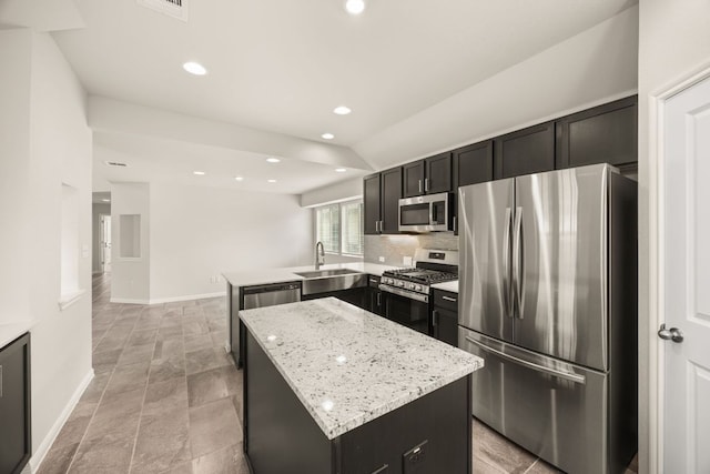 2813 Hopi Path Unit 11, Georgetown, TX 78628 - kitchen featuring a peninsula, baseboards, a center island, a sink, and appliances with stainless steel finishes