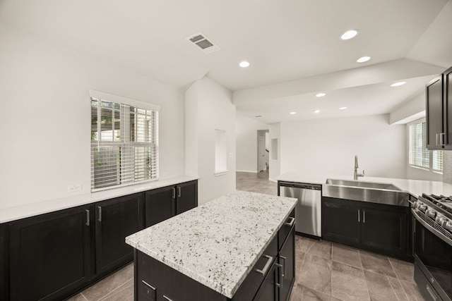2813 Hopi Path Unit 11, Georgetown, TX 78628 - kitchen featuring appliances with stainless steel finishes, a sink, dark cabinetry, a center island, and visible vents