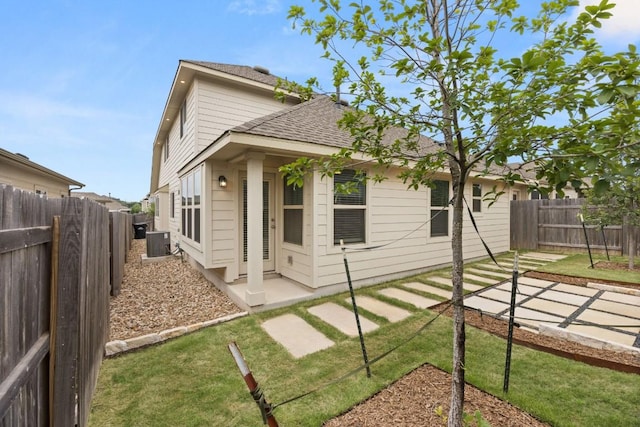 2813 Hopi Path Unit 11, Georgetown, TX 78628 - back of property featuring a fenced backyard, central AC unit, a shingled roof, and a patio