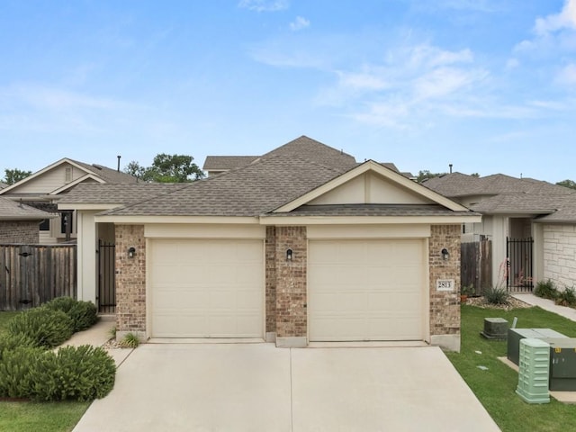 2813 Hopi Path Unit 11, Georgetown, TX 78628 - view of front of home featuring fence, an attached garage, concrete driveway, and brick siding