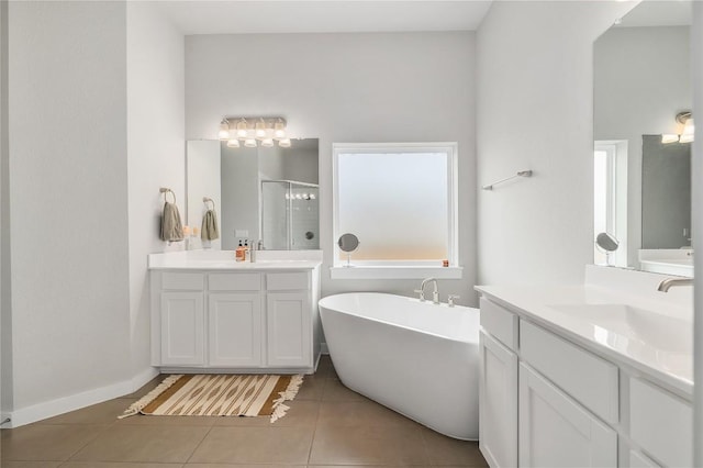 8600 Chrysler Bnd, Austin, TX 78744 - full bathroom featuring a stall shower, tile patterned floors, two vanities, and a freestanding tub