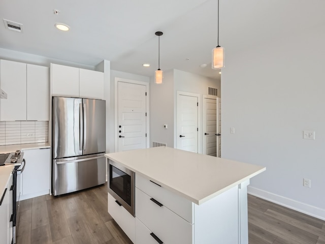 kitchen with white cabinets, light countertops, dark wood finished floors, stainless steel appliances, and recessed lighting