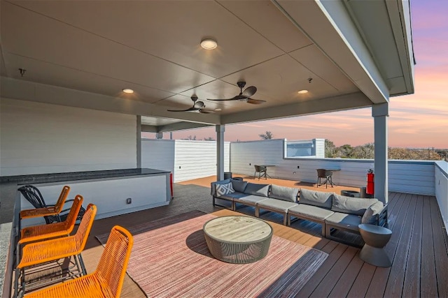 wooden terrace with a ceiling fan and an outdoor living space