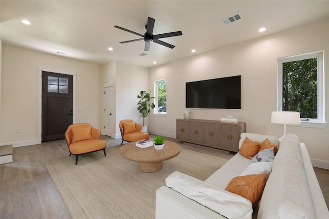 living area featuring recessed lighting, baseboards, visible vents, and wood finished floors