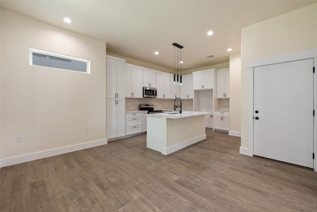 1000 Vargas Rd Unit A, Austin, TX 78741 - kitchen featuring stainless steel appliances, white cabinets, backsplash, light countertops, and recessed lighting