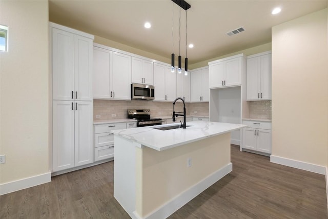 kitchen with appliances with stainless steel finishes, tasteful backsplash, dark wood finished floors, and visible vents