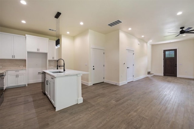 kitchen with white cabinets, a sink, tasteful backsplash, stainless steel dishwasher, and visible vents