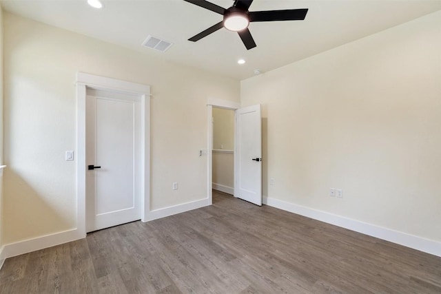 unfurnished bedroom featuring baseboards, recessed lighting, wood finished floors, and visible vents