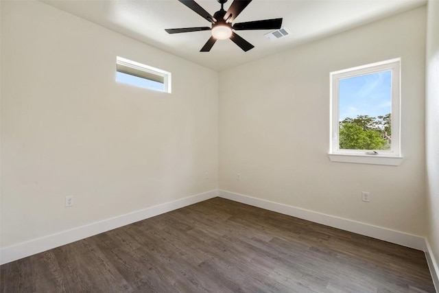 spare room featuring baseboards, plenty of natural light, dark wood-style floors, and ceiling fan