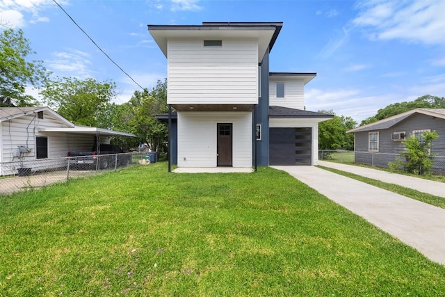exterior space with an attached garage, fence, driveway, and a front yard