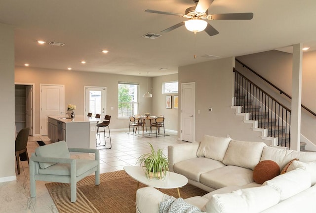 living area with visible vents, baseboards, and ceiling fan