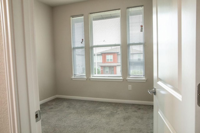unfurnished room featuring carpet floors and baseboards