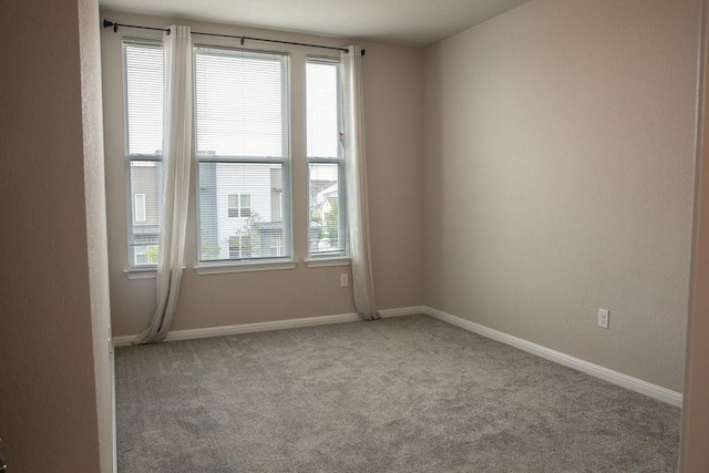 carpeted spare room with baseboards