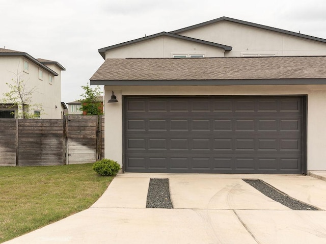 garage featuring fence and driveway