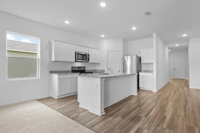 kitchen featuring a sink, white cabinetry, a kitchen island with sink, and stainless steel appliances