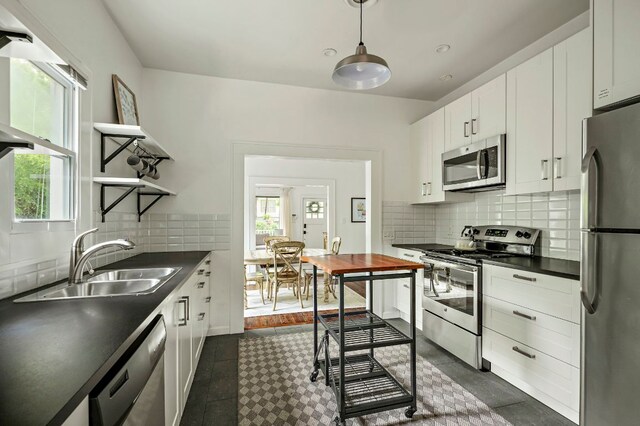 1613 Garden St, Austin, TX 78702 - kitchen with stainless steel appliances, dark countertops, healthy amount of natural light, and tasteful backsplash