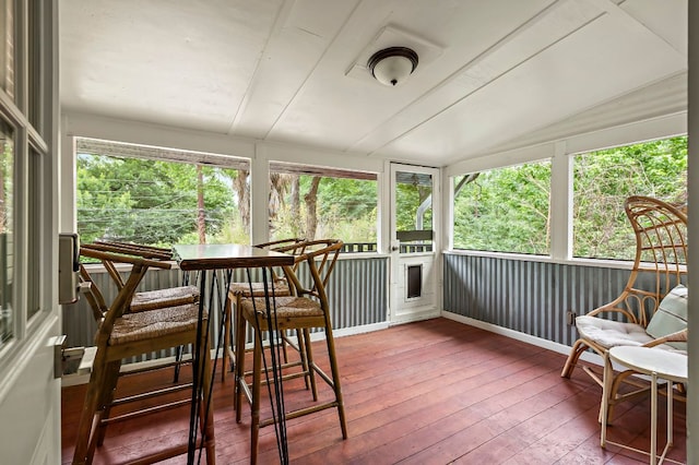 sunroom with wood-type flooring and lofted ceiling