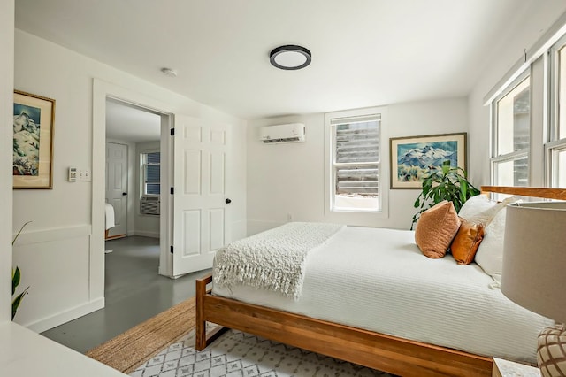 bedroom with baseboards, concrete floors, and a wall mounted air conditioner