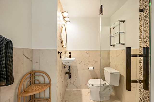 bathroom featuring marble finish floor, a wainscoted wall, toilet, and tile walls