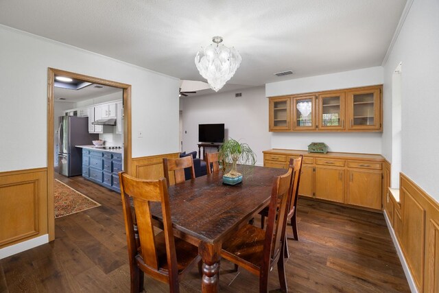 dining space featuring a wainscoted wall, dark wood-type flooring, and visible vents