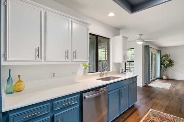 kitchen with a sink, stainless steel dishwasher, blue cabinets, and white cabinetry