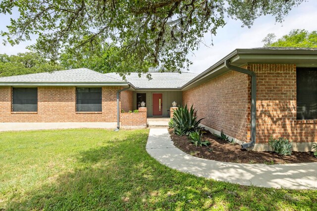 single story home with brick siding and a front lawn