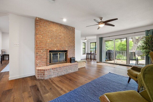 living area with ceiling fan, a fireplace, wood finished floors, baseboards, and recessed lighting