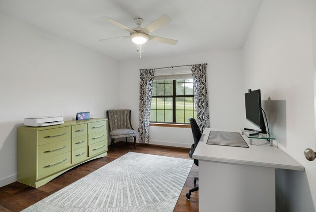 home office with baseboards, a ceiling fan, and dark wood-style flooring