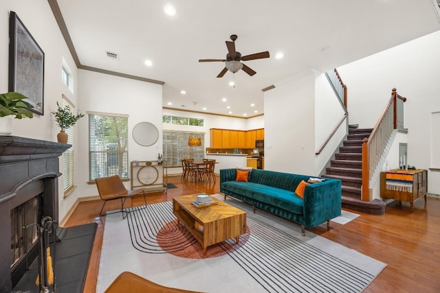 living area with recessed lighting, a ceiling fan, light wood-style flooring, and a fireplace