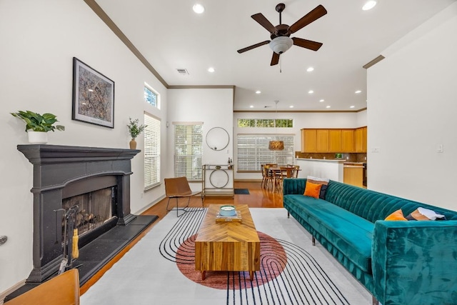 living area featuring recessed lighting, a ceiling fan, and a fireplace with raised hearth