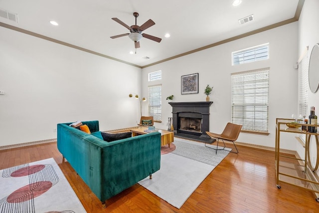 6704 Menchaca Rd Unit 43, Austin, TX 78745 - living room featuring crown molding, ceiling fan, a fireplace, light wood finished floors, and healthy amount of natural light