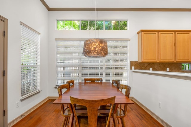 dining room featuring ornamental molding, wood finished floors, and a healthy amount of sunlight