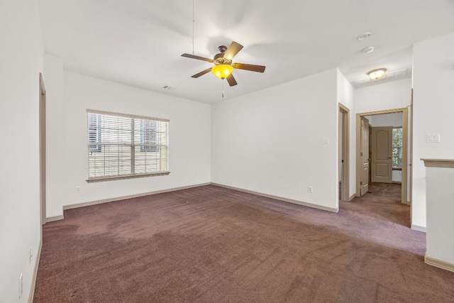 carpeted spare room featuring baseboards and a ceiling fan