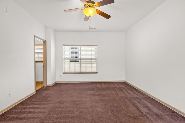 carpeted empty room with baseboards, a ceiling fan, and visible vents