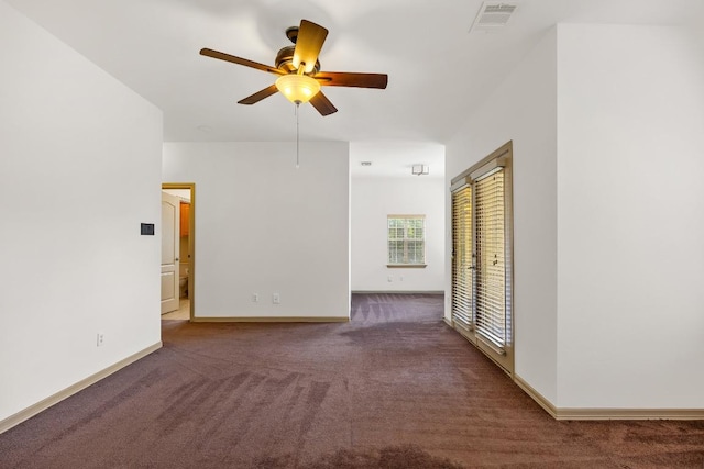 carpeted spare room with ceiling fan, visible vents, and baseboards