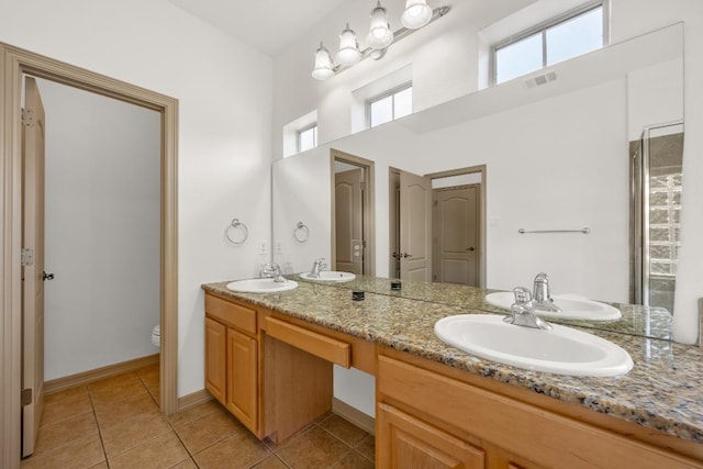 6704 Menchaca Rd Unit 43, Austin, TX 78745 - full bathroom with double vanity, toilet, tile patterned floors, and baseboards